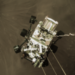 Widok w dół z lądownika na podwieszony pod nim łazik tuż przed dotknięciem powierzchni Marsa